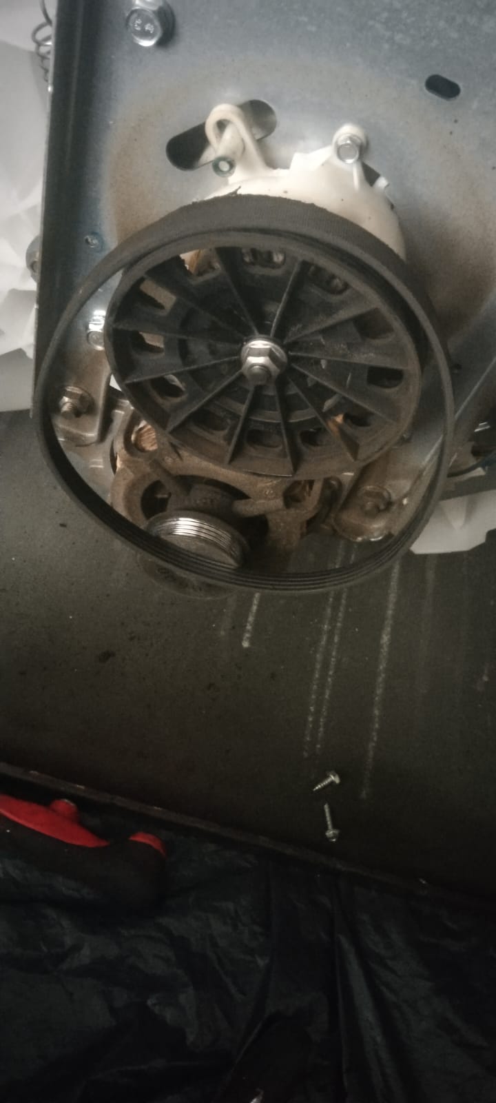 Motor y correa de lavadora durante una reparación